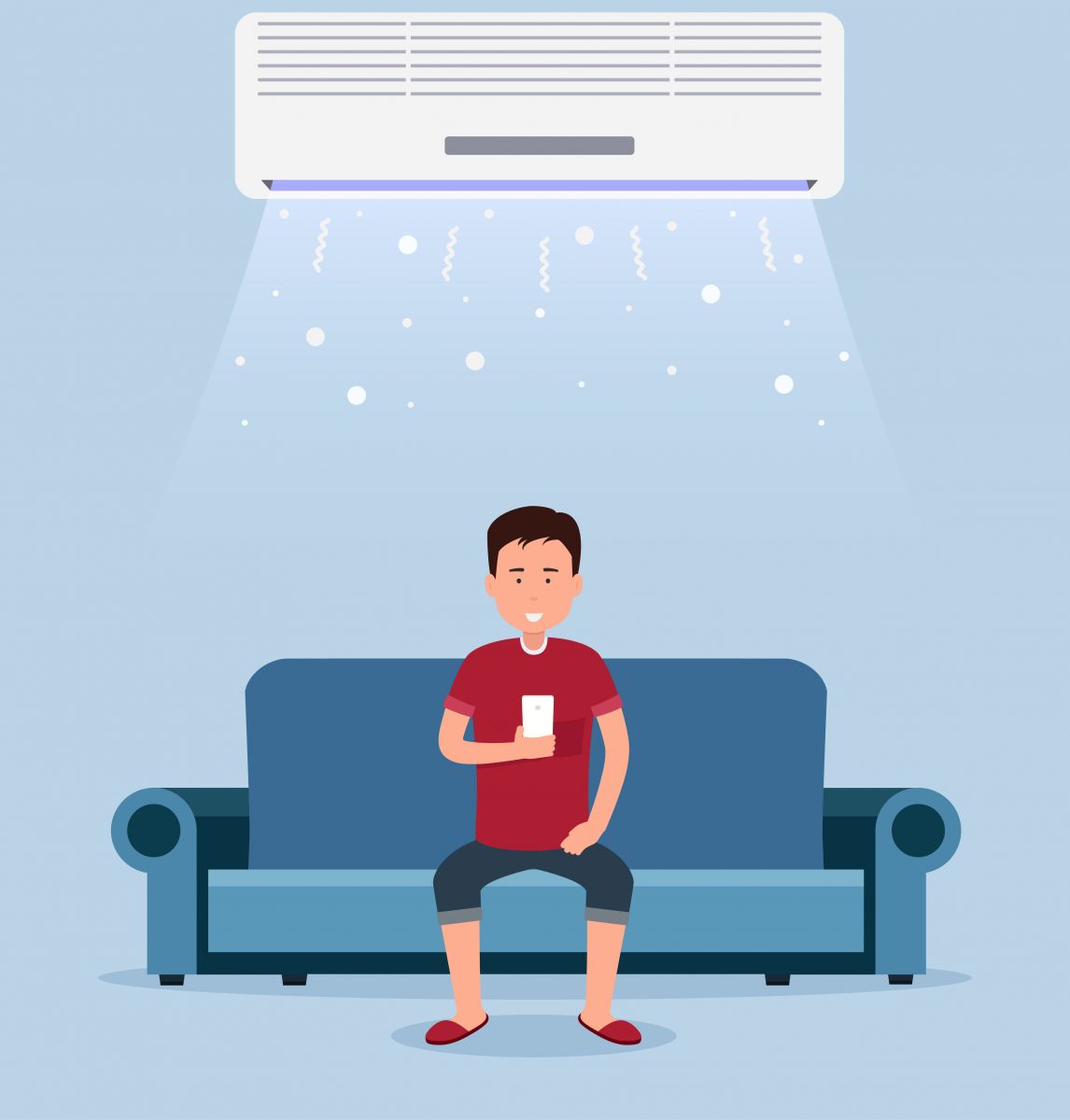 Man sitting on the couch enjoying the benefits of a ductless mini split system while on his phone